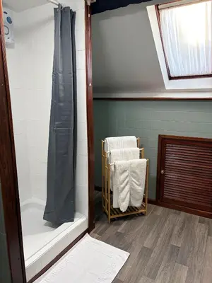 a bathroom with a shower and a chair in it at The Black Swan Inn in Leominster