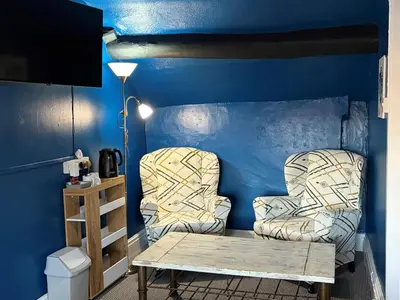 two chairs and a table in a room with blue walls at The Black Swan Inn in Leominster