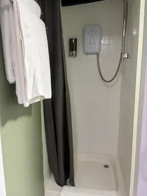 a shower with a black shower curtain in a bathroom at The Black Swan Inn in Leominster