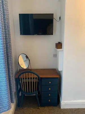 a small desk with a mirror and a chair at Abbots Mead Hotel in Shrewsbury