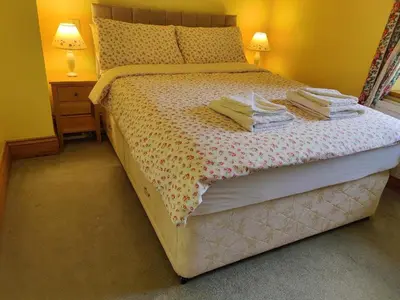 a bed in a bedroom with two lamps and two tables at Bryn Cottage in Llandderfel