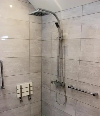 a shower with a shower head in a bathroom at Dee Valley Cottages in Llangollen