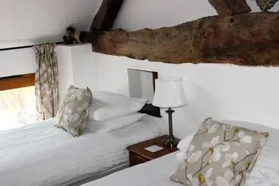 a bedroom with two beds and a table with a lamp at Dee Valley Cottages in Llangollen