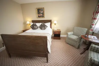 a hotel room with a bed and a chair at The Lion Hotel Shrewsbury in Shrewsbury