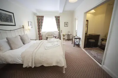 a bedroom with a large white bed and a mirror at The Lion Hotel Shrewsbury in Shrewsbury