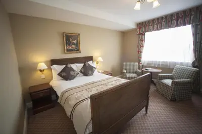 a hotel room with a bed and a chair and a window at The Lion Hotel Shrewsbury in Shrewsbury