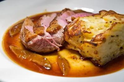 a plate of food with a piece of meat and sauce at The Wynnstay in Machynlleth