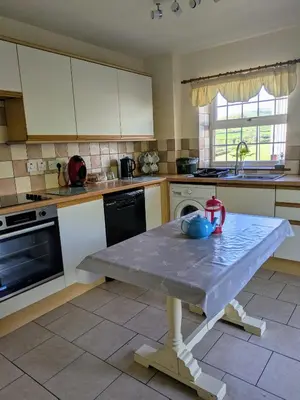 a kitchen with a table in the middle of it at Sunnyside farmstay & hottub near Brecon Beacons sleeps 8 in Lower Chapel