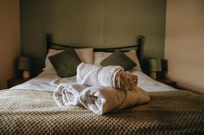 a pile of towels sitting on top of a bed at Sunnyside farmstay & hottub near Brecon Beacons sleeps 8 in Lower Chapel