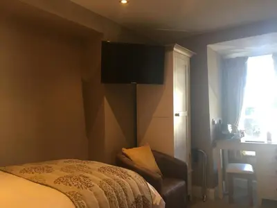 a bedroom with a bed and a television on the wall at Plas Yn Dre in Bala