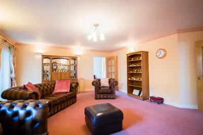 a living room with a couch and a chair at Y Grange in Llanfihangel-y-creuddyn