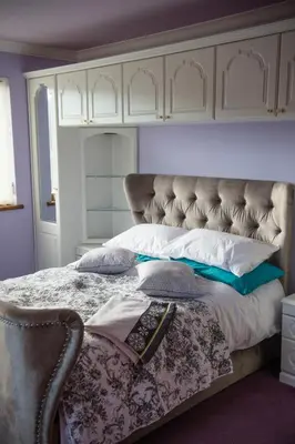 a bedroom with a large bed with a large headboard at Y Grange in Llanfihangel-y-creuddyn