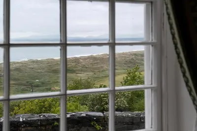 a window with a view of the countryside seen through it at Crown Lodge in Harlech