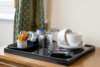 a tray with cups and dishes on a table at Crown Lodge in Harlech