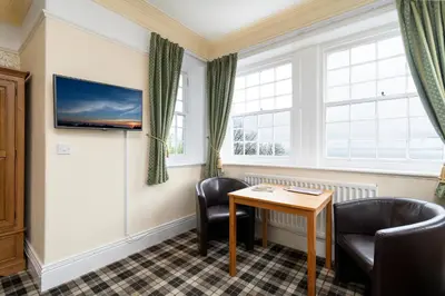 a waiting room with a table and chairs at Crown Lodge in Harlech