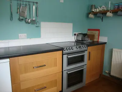 a kitchen with a stove and a counter top at Ceiros Cottage in Llangammarch Wells