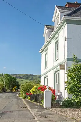 a white house on the side of a street at Llety Brynawel Guest House in Pennal
