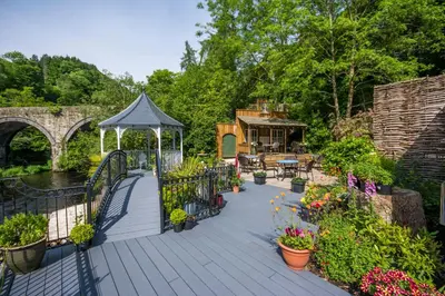 a wooden deck with a gazebo and some plants at The Chainbridge Hotel in Llangollen