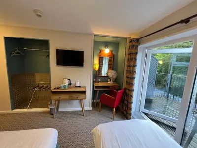 a hotel room with a bed and a desk and a window at The Chainbridge Hotel in Llangollen