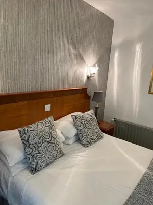 a bedroom with a bed with two pillows on it at The Chainbridge Hotel in Llangollen