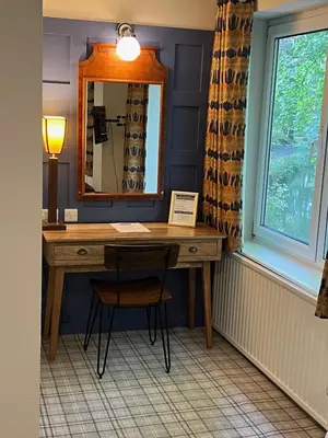 a desk in a room with a mirror and a chair at The Chainbridge Hotel in Llangollen