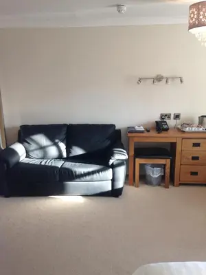 a black leather couch in a living room with a desk at The Elephant & Castle Hotel in Newtown