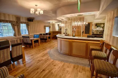 a restaurant with a bar and tables and chairs at The Elephant & Castle Hotel in Newtown