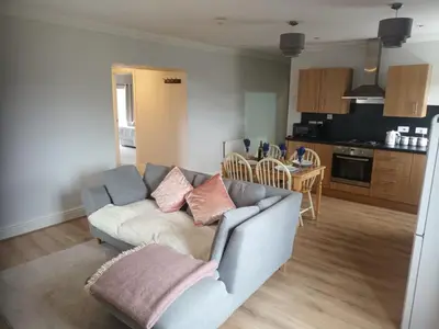 a living room with a couch and a kitchen at Llanina Arms in Llanarth