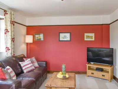 a living room with a couch and a flat screen tv at Brynllin Holiday Cottages - Dildre in Penuwch