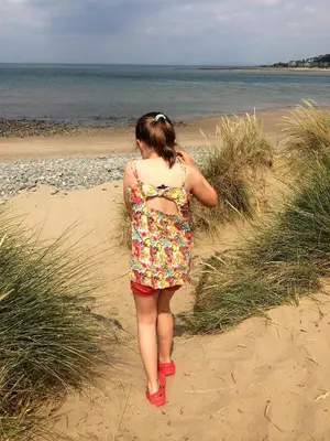 a young girl is walking on the beach at Snowdonia Snug - Studio Style Accommodation in Dolgellau
