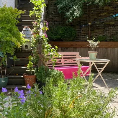 a garden with a bench and a table and plants at Snowdonia Snug - Studio Style Accommodation in Dolgellau