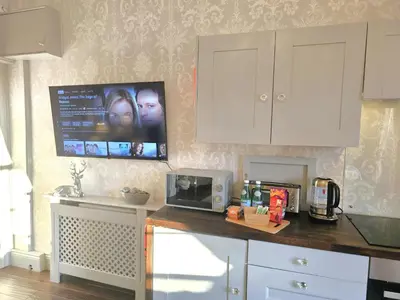 a kitchen counter with a microwave and a tv on the wall at Beautifully decorated, elegant apartment near town - Pass the Keys in Shrewsbury