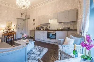 a kitchen and living room with a couch and a table at Beautifully decorated, elegant apartment near town - Pass the Keys in Shrewsbury