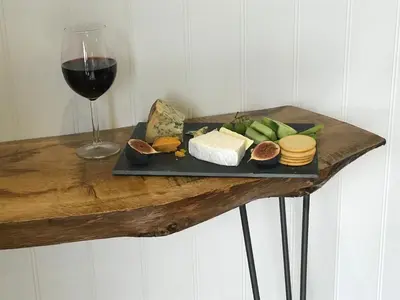 a plate of cheese and a glass of wine on a table at The Pod & Cwtch luxury accommodation in Aberaeron