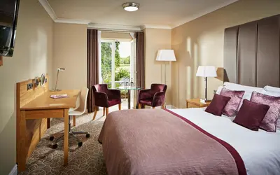 a hotel room with a bed and a desk at Lion Quays Resort in Oswestry