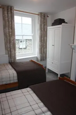 a bedroom with two beds and a window at Delfryn Cottage in Rhayader