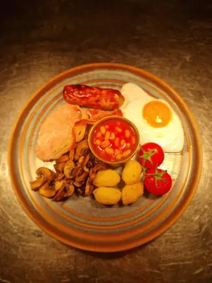 a plate of breakfast food with eggs sausage and beans at Y Branwen Restaurant & Rooms - Adult Only and Dog Friendly in Harlech
