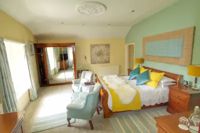 a bedroom with a bed and a chair at Pen-Y-Dyffryn Country Hotel in Oswestry