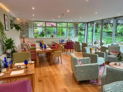 a restaurant with tables and chairs and windows at Pen-Y-Dyffryn Country Hotel in Oswestry
