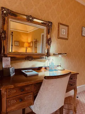 a wooden desk with a mirror on a wall at The Falcondale Country House Hotel in Lampeter