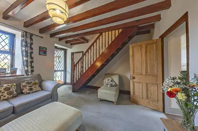 a living room with a couch and a staircase at Gwynfryn in Cerrig-y-Druidion