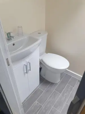 a bathroom with a white toilet and a sink at Leamington House in Barmouth