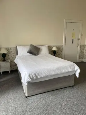 a bedroom with a bed with white sheets and pillows at Seascape in Barmouth