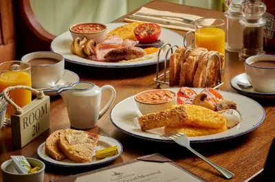 a wooden table topped with plates of breakfast foods at The Glengower in Aberystwyth
