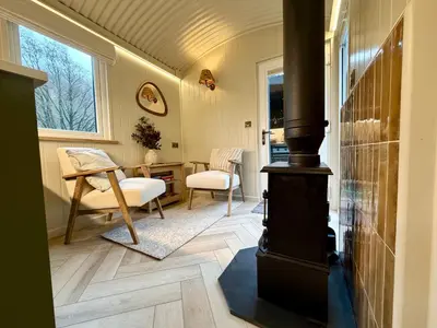 a living room with a wood stove in a room at Cegir Escapes in Darowen
