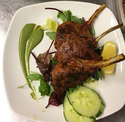 a plate of food with meat and vegetables on a table at New Gurkha Inn in Brecon