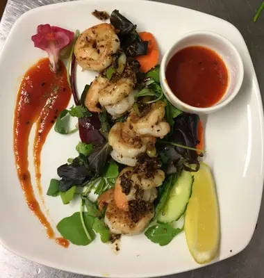 a plate of shrimp and vegetables with a dipping sauce at New Gurkha Inn in Brecon