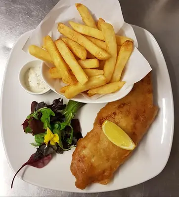 a plate of food with fish and french fries at New Gurkha Inn in Brecon