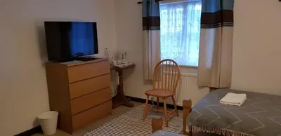 a bedroom with a bed and a television on a dresser at New Gurkha Inn in Brecon