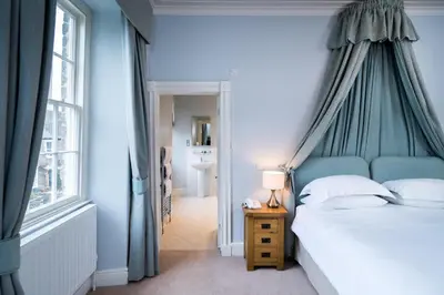 a bedroom with a bed with a blue canopy at The Swan At Hay in Hay-on-Wye